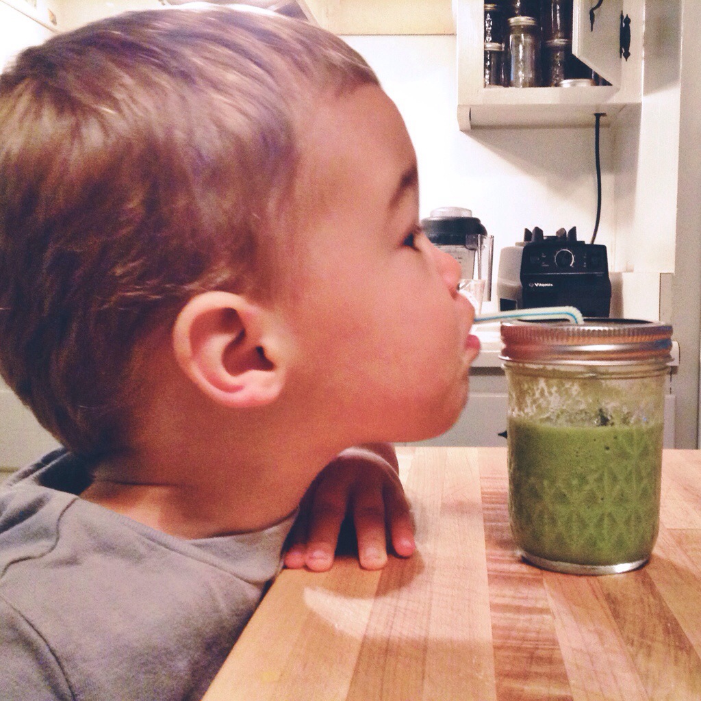 toddler enjoying his green smoothie
